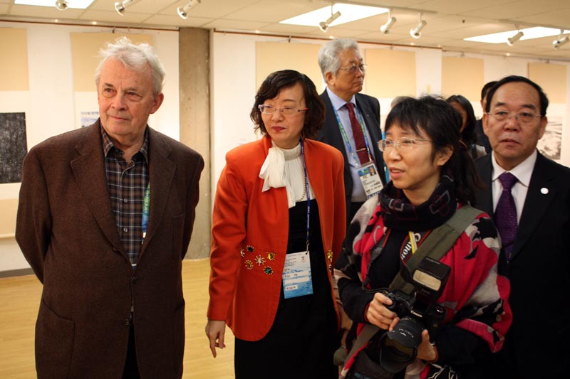 冰雪画会秘书长卢平向国际奥委会全民体育委员会主席瓦尔特·特勒格尔等介绍中国冰雪画