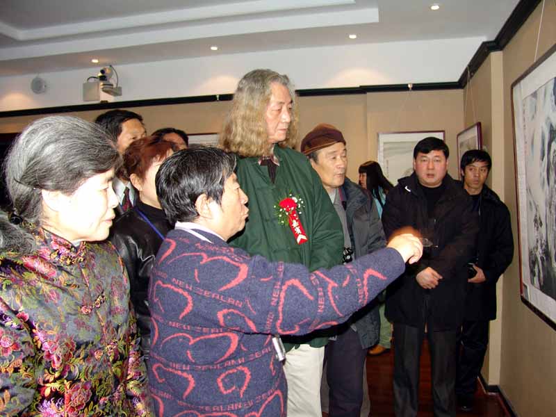 于志学向美术主编王仲先生介绍冰雪画派作品