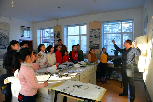 教师王文举在逊克县青少年活动中心辅导中小学生学习冰雪画